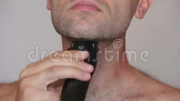 用电动剃须刀刮胡子的无衫人视频的预览图