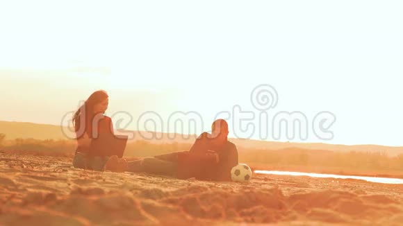 坐在沙滩上一男一女笑慢动作视频视频的预览图