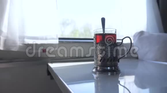 铁路旅行概念一杯玻璃杯中装有勺子的茶一个老式的站在火车车厢的桌子上视频的预览图