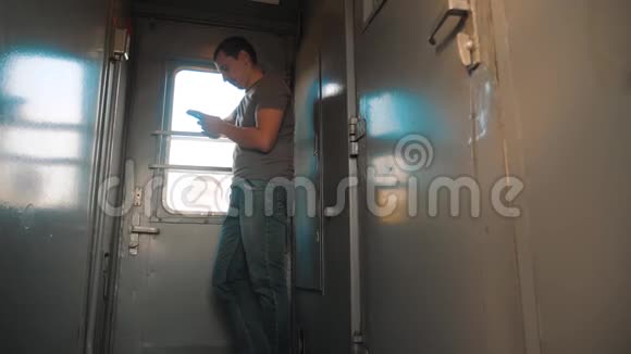 那个人的轮廓站在火车车厢上手里拿着一部智能手机慢动作视频男人写字视频的预览图