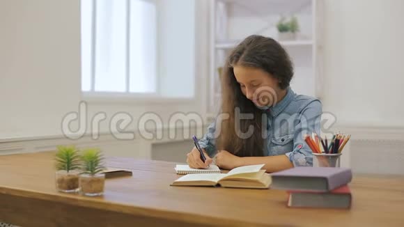 带手提电脑的年轻女孩正在做作业大学教育女学生在家学习视频的预览图