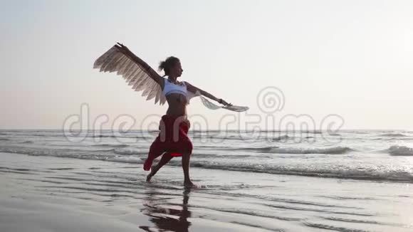 日落时分有天使翅膀在跳舞的年轻女孩视频的预览图