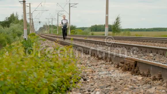 人在铁轨上的铁轨之间奔跑视频的预览图