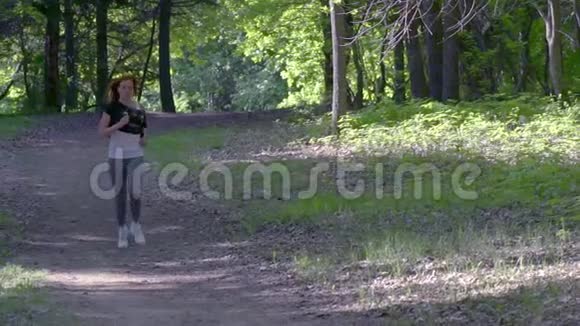 慢动作年轻女子早上穿过公园视频的预览图
