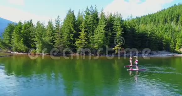一对夫妇在河里划船一个站起来的桨板视频的预览图