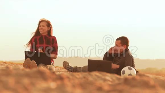 女孩和男人坐在第三个男人的手提电脑慢动作视频视频的预览图