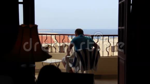 男人在阳台上俯瞰大海女人在床上争吵男女视频的预览图