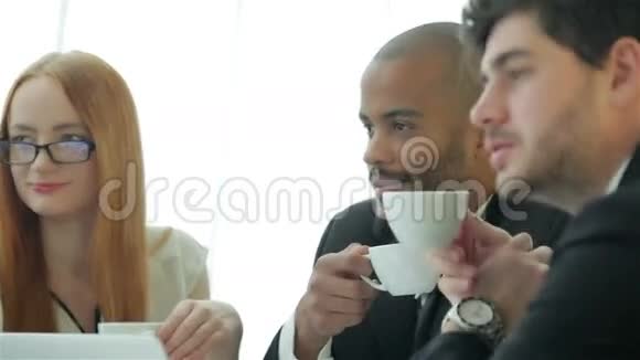 四个微笑的成功商人喝咖啡视频的预览图