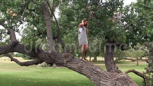 穿灰色衣服的女人和站在公园树上的桑德斯视频的预览图