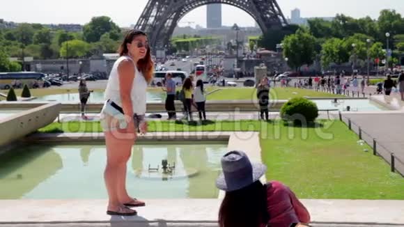 法国巴黎2015年6月8日在著名的埃菲尔铁塔附近摆姿势的女孩视频的预览图