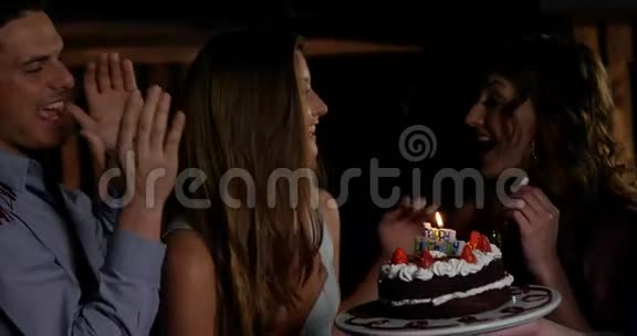 一群微笑的朋友在酒吧里吹蜡烛庆祝生日视频的预览图