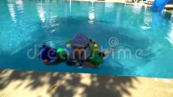 快乐的小孩子在游泳池里洗澡和游泳小女孩喜欢游泳视频的预览图