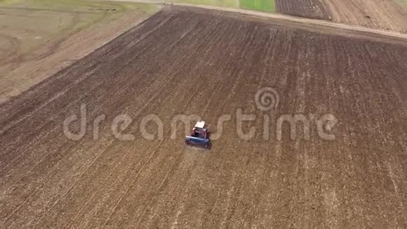 4k拖拉机联合收割机耕田的高空俯视图视频的预览图