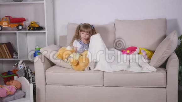 美丽的小女孩睡前躺在沙发上视频的预览图