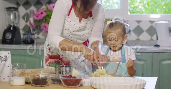 可爱的小女孩帮她妈妈烤东西视频的预览图
