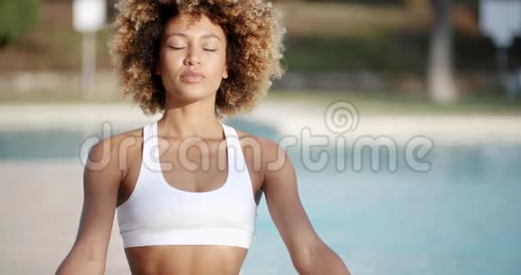 健康的女人在游泳池附近冥想视频的预览图