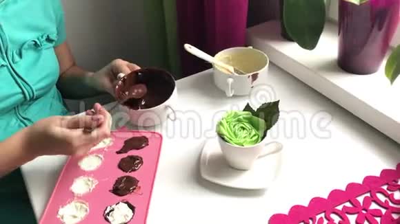 一个女人用融化的巧克力密封一个硅胶填充做甜点视频的预览图