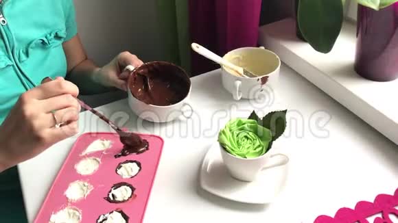 一个女人用融化的巧克力密封一个硅胶填充做甜点视频的预览图