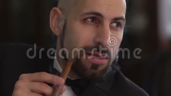 优雅的男人穿着西装抽着雪茄动作缓慢视频的预览图