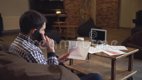 一个穿衬衫的男人手里拿着一张图表在电话里说话视频的预览图