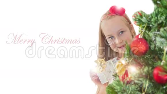 圣诞树后有礼物盒的小女孩视频的预览图
