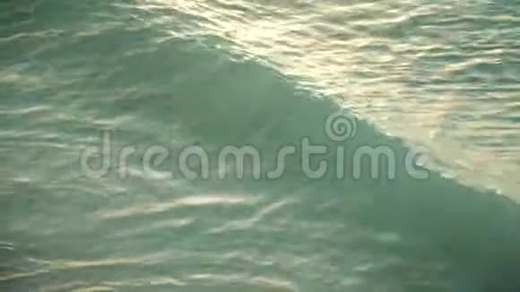 日落时沙滩上的海浪翻滚视频的预览图