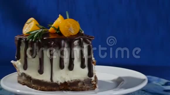 在深蓝色背景的桌子上放着美味的巧克力蛋糕一块巧克力蛋糕和香草奶油空投视频的预览图