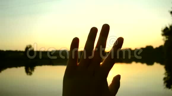 黑色的手的轮廓在空中移动通过手指穿过阳光视频的预览图