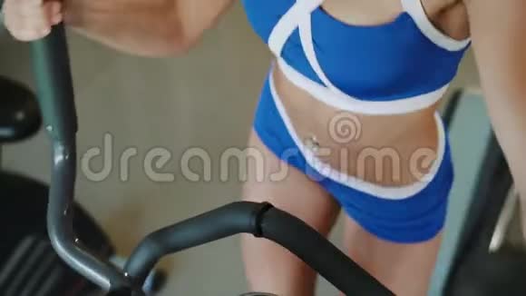 漂亮的女运动员在健身房里用模拟器锻炼4K视频的预览图