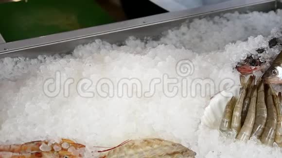 厨师的双手把新鲜的虾放在一家海鲜餐馆的冰上视频的预览图