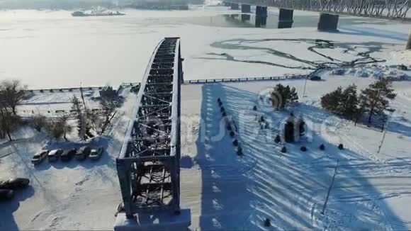 在桥上飞行飞越冰冻的河流跨河大桥视频的预览图