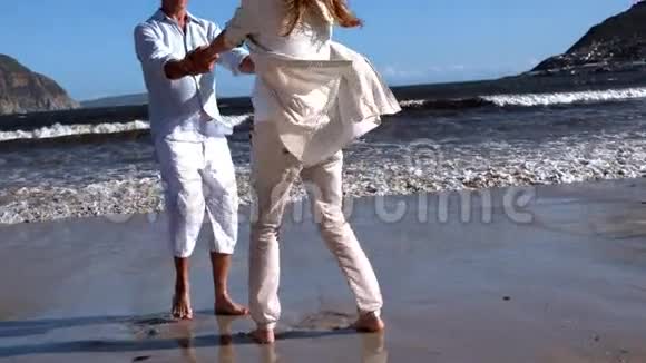 一对无忧无虑的情侣在海滩上转悠视频的预览图