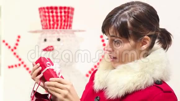 圣诞妇女打开礼物和微笑的袋子雪人在后台视频的预览图
