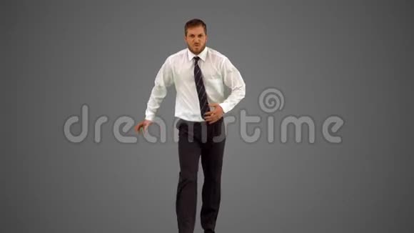 商人走向镜头在灰色背景下滑稽地跳舞视频的预览图