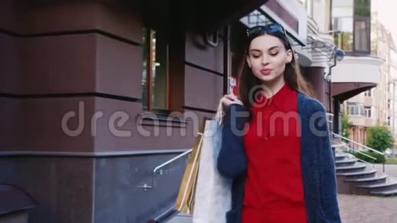 时尚的女人带着购物袋在城里散步视频的预览图