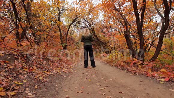 金发女孩在秋天的森林里锻炼视频的预览图