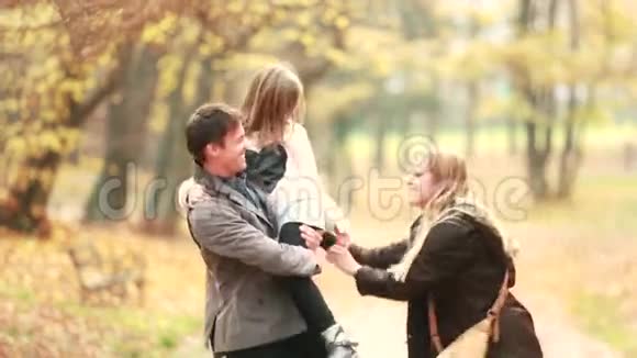 一家人在公园里散步爸爸抱着女儿妈妈逗她开心视频的预览图