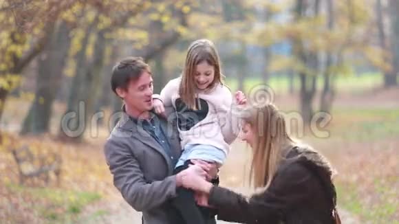 一家人在公园里散步爸爸抱着女儿妈妈逗她开心视频的预览图