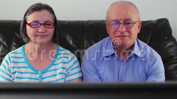 快乐的老年夫妇看电视视频的预览图