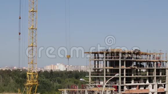 用混凝土制成的建筑框架施工工人们正沿着上层移动一台塔式起重机视频的预览图