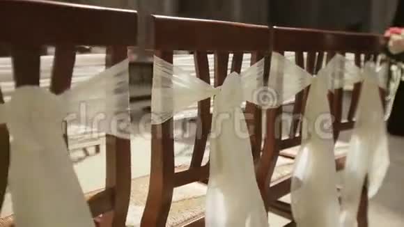 婚礼上的结婚椅上装饰着白色丝绸蝴蝶结视频的预览图