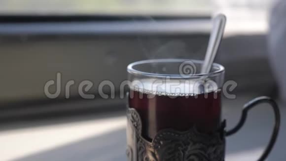 铁路旅行概念在玻璃生活方式中用勺子喝茶老式的老式的站在火车车厢的桌子上视频的预览图