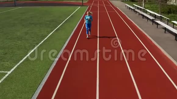在露天体育场奔跑的性感金发女人视频的预览图