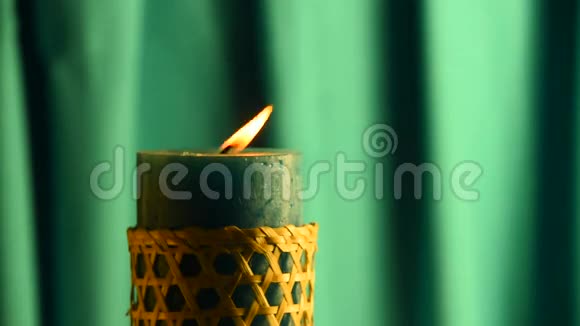 泰尔蜡烛用绿色的窗帘背景颤抖的火焰吹灭视频的预览图