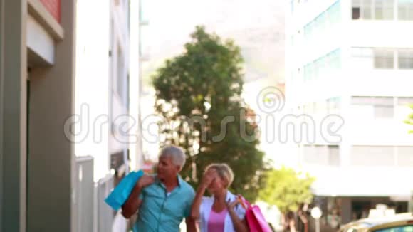 快乐的一对夫妇在外面购物散步牵手视频的预览图
