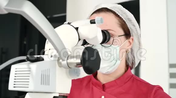 一位女性专业牙医在她的办公室里用雄蕊显微镜检查一位女性病人斯塔姆学家视频的预览图