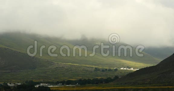 西藏一个村庄的山顶和山谷上44k的蓬松云视频的预览图