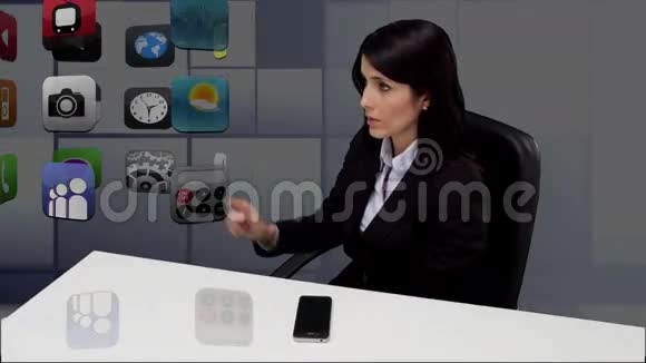 女商人坐在办公桌前滚动着申请视频的预览图