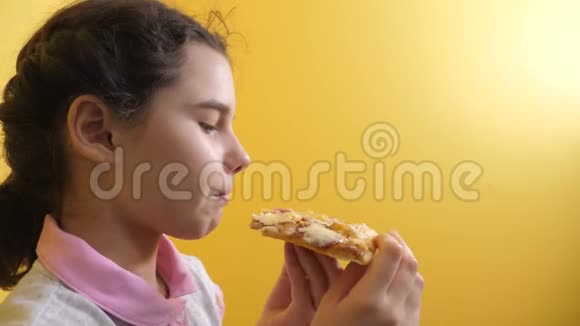 快乐的小女孩吃一片披萨的概念青少年儿童饥饿吃一片生活方式披萨慢动作视频的预览图