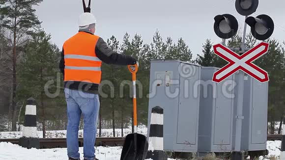在信号灯附近用雪铲工作的工人视频的预览图